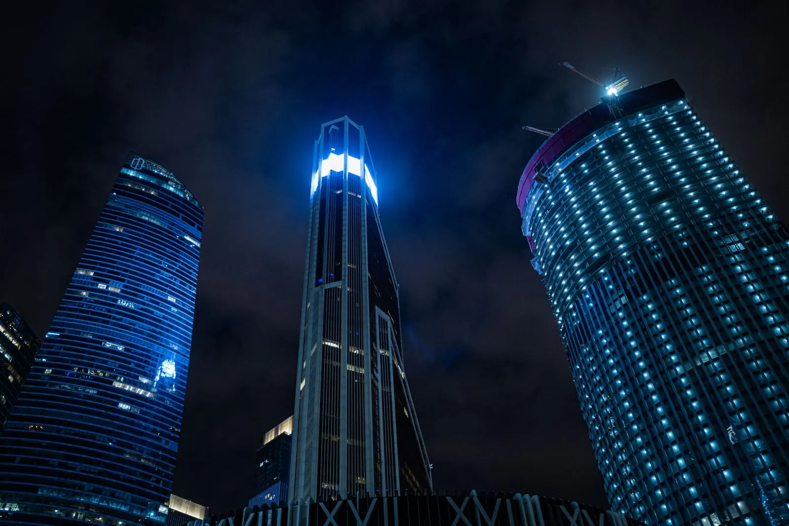 Three glass office towers lit blue against a night sky, representing the Banking and Financial Services industry